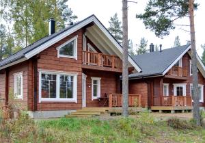 a large wooden house with a large deck at Puttitie 4B in Tahkovuori