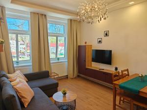 a living room with a couch and a tv at Apartmány Promenáda in Trutnov