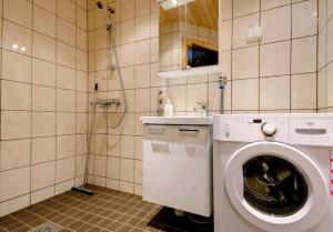 a bathroom with a washing machine and a shower at Puttitie 4B in Tahkovuori