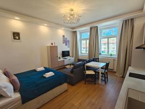 a bedroom with a bed and a couch and a table at Apartmány Promenáda in Trutnov