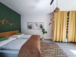 a bedroom with a bed and a green wall at La Vida appartment 1 in Klagenfurt