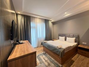 a bedroom with a bed and a flat screen tv at Baza Hotel Spa in Beylǝqan
