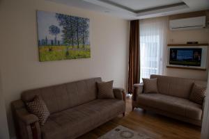 a living room with two couches and a painting on the wall at Ada Apart Hotel in Antalya