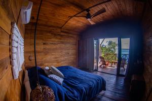 Ein Mann schläft in einem Bett in einem Zimmer in der Unterkunft Cabaña Jules in Bacalar