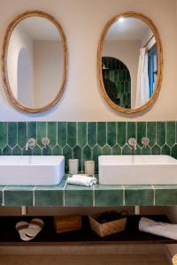 a bathroom with two sinks and two mirrors at Les Paillers de Bodri - Vue mer et piscine - Adults Only in Corbara +42 photos