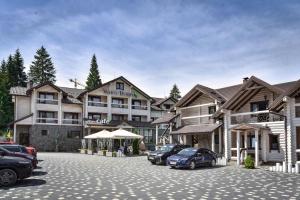 a large hotel with cars parked in a parking lot at Whiteberry hotel in Bukovel