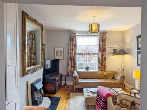 a living room with a couch and a television at Gainsford - Arundel in Arundel
