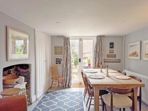 a dining room with a table and chairs and a fireplace at Gainsford - Arundel in Arundel