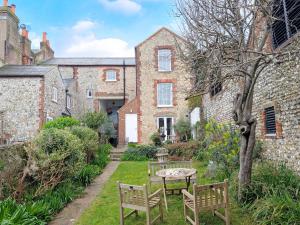 a garden with chairs and a table in front of a building at Gainsford - Arundel in Arundel