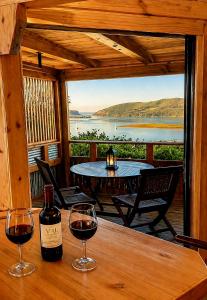 two glasses of wine sitting on a table on a porch at Paradise Private Zen Studios in Knysna