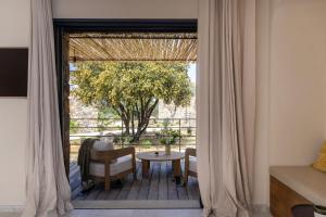 a room with a table and chairs and a window at Les Paillers de Bodri - Vue mer et piscine - Adults Only in Corbara