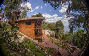 ein Baumhaus mit einem Steg, der dorthin führt in der Unterkunft Cabaña Jules in Bacalar