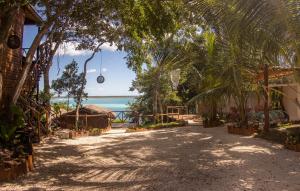 Eine Straße mit Bäumen und dem Meer im Hintergrund in der Unterkunft Cabaña Jules in Bacalar + 17 Fotos
