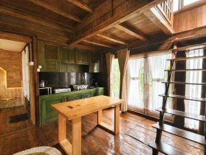 a kitchen with green cabinets and a wooden table at Dulang Resort & Resto in Bongkar 2