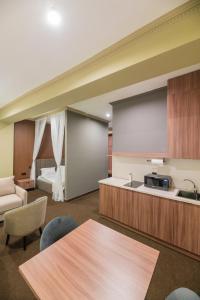 a kitchen with a table and a couch and a bed at UIDE Apart hotel in Almaty