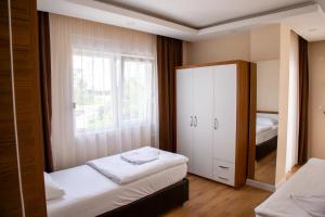 a small bedroom with two beds and a mirror at Ada Apart Hotel in Antalya +147 photos