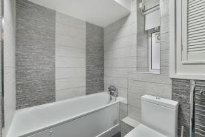 uma casa de banho com banheira e WC em Sachin's 2 Bedrooms Apartment em Londres