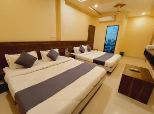 a hotel room with two beds and a window at shree krishna Hotel in Ujjain +58 photos