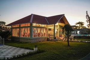 a large house with a gambrel roof at Jai Ganesha Resort in Chālsa Mahābāri