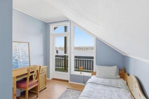 a bedroom with a bed and a desk and a window at Waterfront Home-Tonsberg in Tønsberg