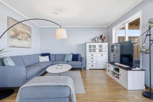 a living room with a blue couch and a table at Waterfront Home-Tonsberg in Tønsberg