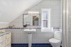 a bathroom with a sink and a toilet and a mirror at Waterfront Home-Tonsberg in Tønsberg +30 photos