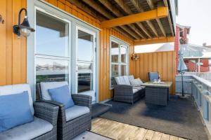 a porch with wicker chairs and a table and windows at Waterfront Home-Tonsberg in Tønsberg