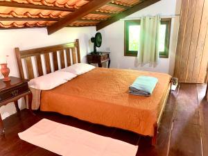 a bedroom with a bed and a table and a window at Pousada Jardim da Vida in Palmeiras