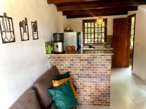 a living room with a couch in front of a kitchen at Pousada Jardim da Vida in Palmeiras