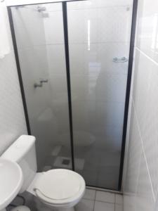 ein Badezimmer mit Toilette und Glasdusche in der Unterkunft Passos Inn Hotel in Passos