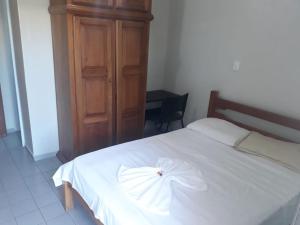 ein Schlafzimmer mit einem weißen Bett mit einer Schleife darauf in der Unterkunft Passos Inn Hotel in Passos