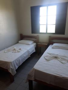 ein Zimmer mit zwei Betten und einem Fenster in der Unterkunft Passos Inn Hotel in Passos