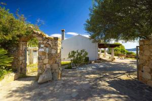 an external view of a house with a stone wall at Panoramic Seaview Coastal Retreat with Pool in Cugnana