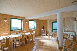 a dining room with tables and chairs and windows at Willa Ewa in Lądek-Zdrój
