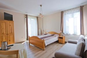 a bedroom with a bed and a couch at Willa Ewa in Lądek-Zdrój