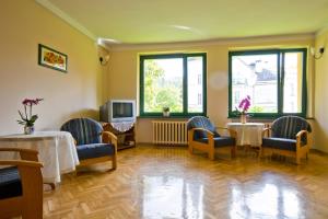 a waiting room with two tables and chairs and windows at Willa Ewa in Lądek-Zdrój