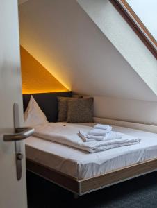 a bed with white sheets and towels on it at Gasthaus Bären Kölliken in Kölliken