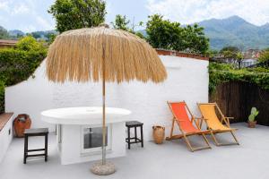 a patio with a table and chairs and an umbrella at Casa Leonardo in Casamicciola Terme