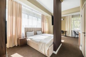 a bedroom with a bed and a large window at UIDE Apart hotel in Almaty