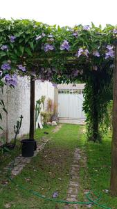 eine Pergola mit lila Blumen in einem Garten in der Unterkunft Arborizado in Camaçari
