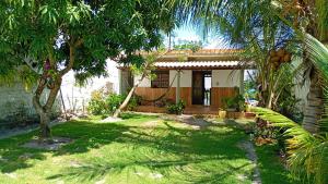 ein Haus mit einem Garten mit Palmen davor in der Unterkunft Arborizado in Camaçari