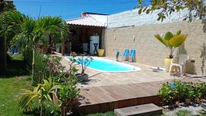 ein Garten mit Swimmingpool und Holzterrasse in der Unterkunft Arborizado in Camaçari