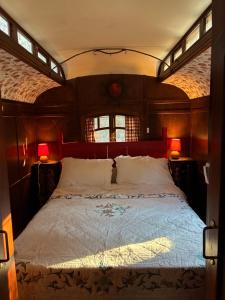 a bedroom with a large bed with two lamps at Idyllic Roulotte in Les Assions