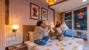 two women sitting on a bed playing with stuffed animals at Zostel McLeodganj in McLeod Ganj