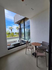 a dining room with a table and chairs and a large window at Suites By Jordan's Hotel in Vlorë