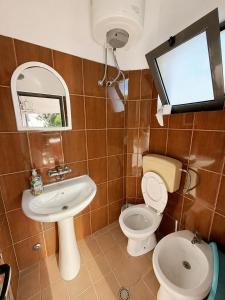 a bathroom with a toilet and a sink and a mirror at Hotel Bar Restaurant MANI in Velipojë +68 photos