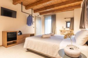 a bedroom with a large bed and a tv at Agriturismo Bramalpane in Bagno di Romagna