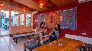 a group of three people sitting in a room at Zostel McLeodganj in McLeod Ganj