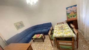 a living room with a blue couch and a table at da Lilia in Salute&Bellezza Business Apartment in Monfalcone