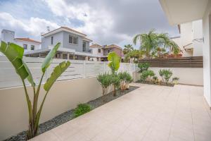 a courtyard in a house with a fence and plants at Mambo Private Villa with Pool by the Beach in Paralimni
